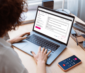 An adult female using a laptop to use two-line voice carry-over service.